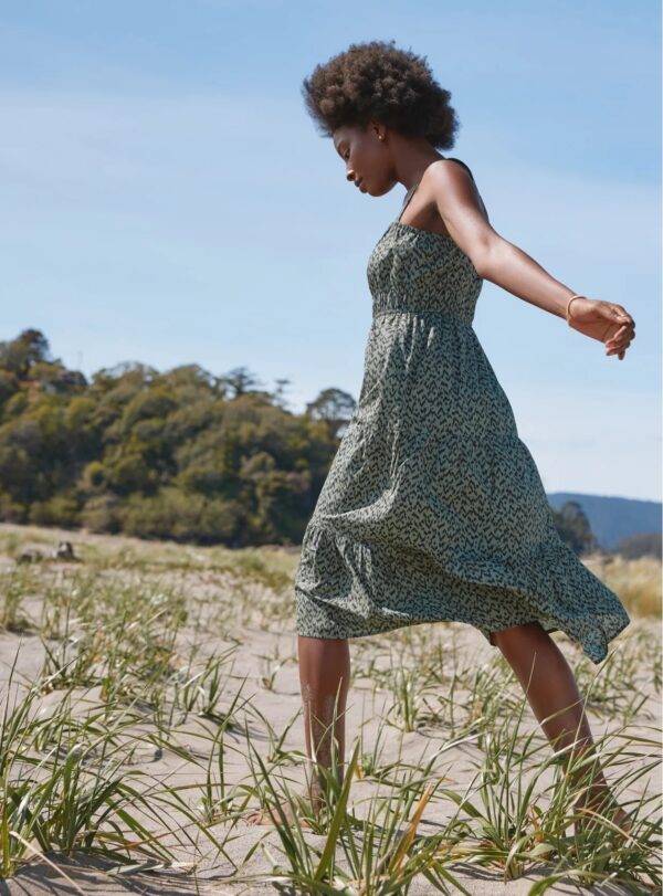 Woman wearing green, dotted dress on beach