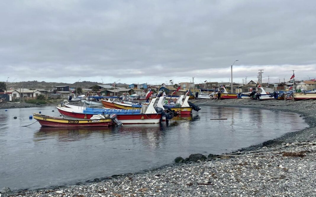 boats anchored offshore a stone-covered shore