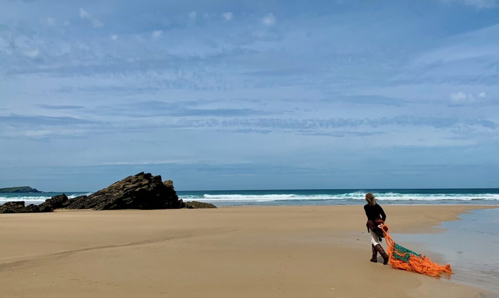 tracey williams walking on beach with net