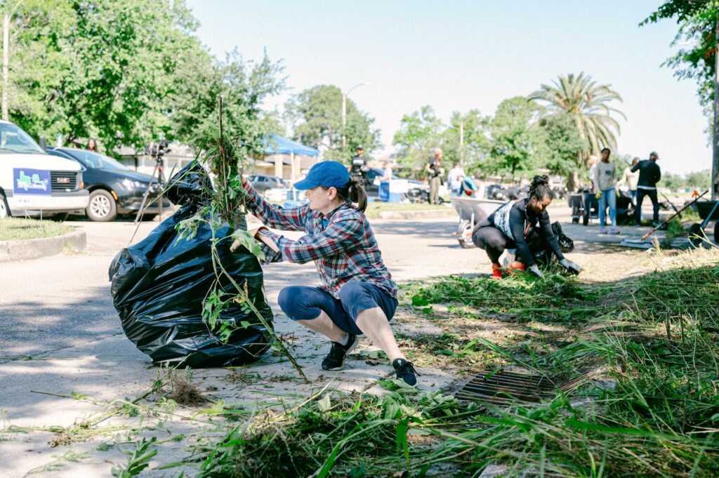 volunteers outside cleaning up overgrown plants